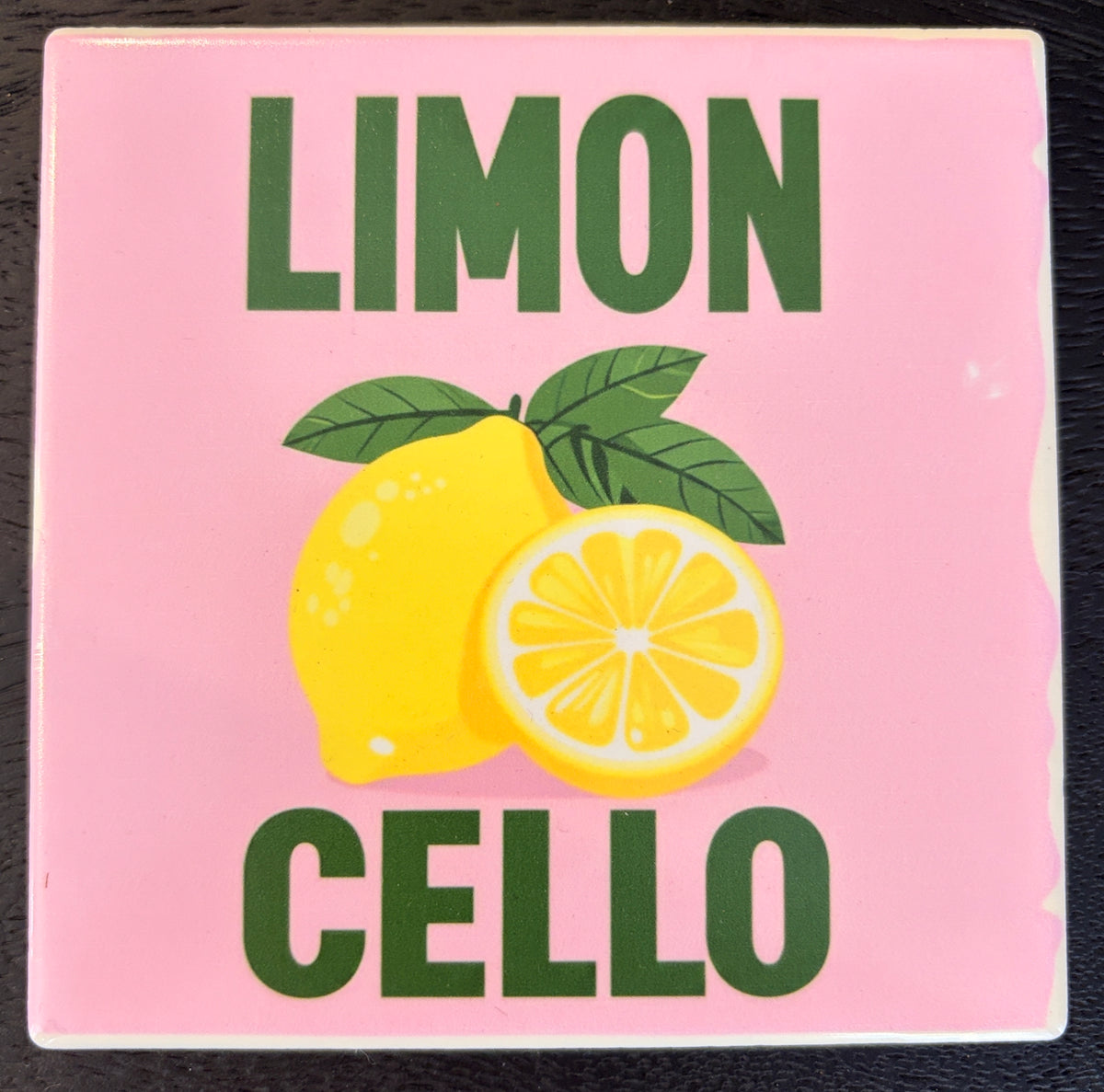 Bedruckte Fliese oder Untersetzer mit dem Schriftzug „LIMON CELLO“ auf rosafarbenem Hintergrund sowie einer gelben Zitrone und einer halbierten Zitrone im mediterranen Design.