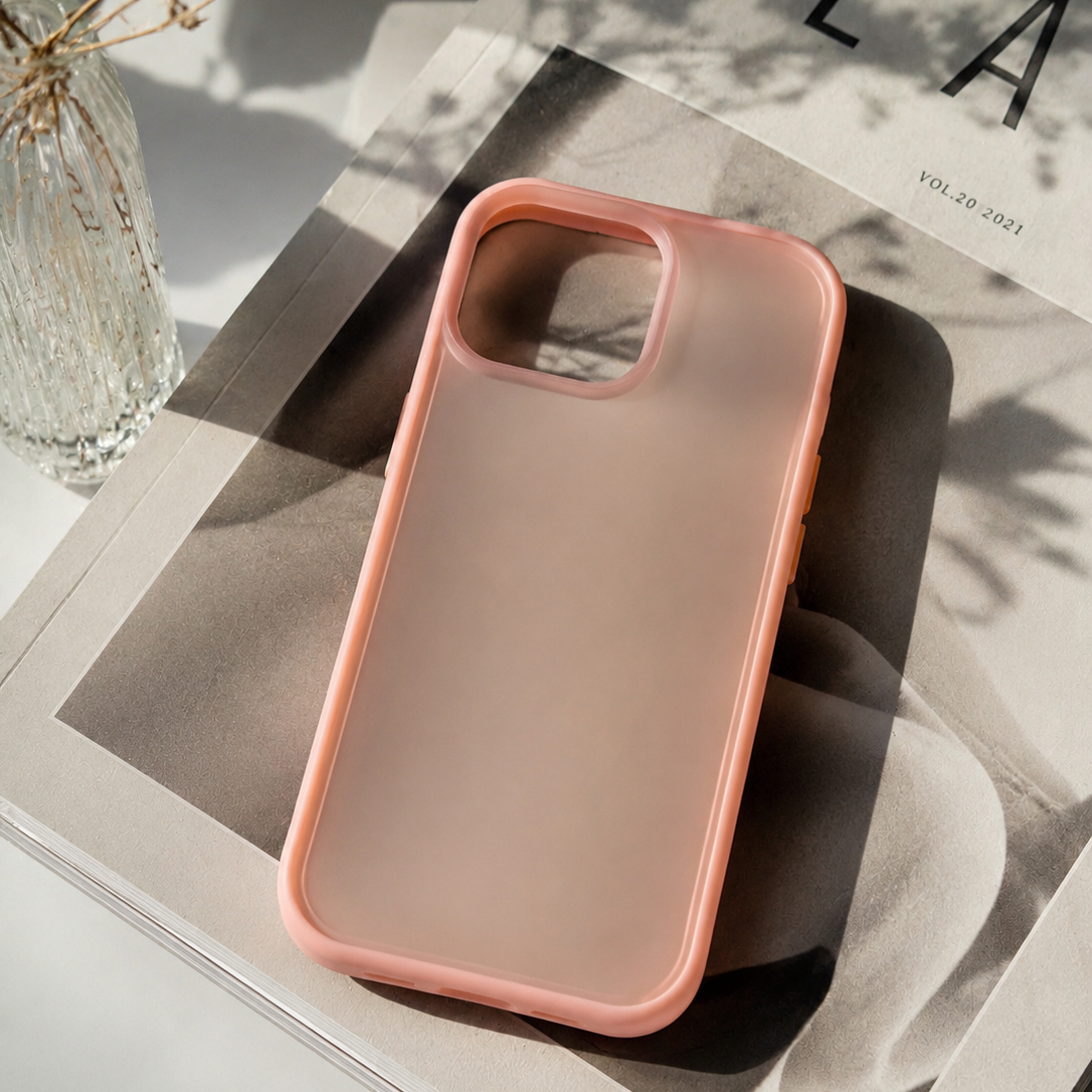 Rosa Handyhülle mit matt-transparenter Rückseite dekorativ auf einem Magazin mit Vase und natürlichem Sonnenlicht arrangiert – modernes Lifestyle-Produktbild.