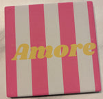 Bedruckte Fliese oder Untersetzer mit rosa-weißem Streifenmuster und dem Schriftzug „Amore“ in Gelb – modernes, mediterran inspiriertes Design.