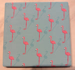 Bedruckte Fliese oder Untersetzer mit modernem Flamingo-Muster in Rosa auf hellblauem Hintergrund – sommerliches Design mit tropischem Flair.