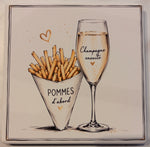 Bedruckte Fliese oder Untersetzer mit Pommes und einem Glas Champagner sowie dem Spruch „Pommes d'abord, Champagne ensuite“ im minimalistischen Design.