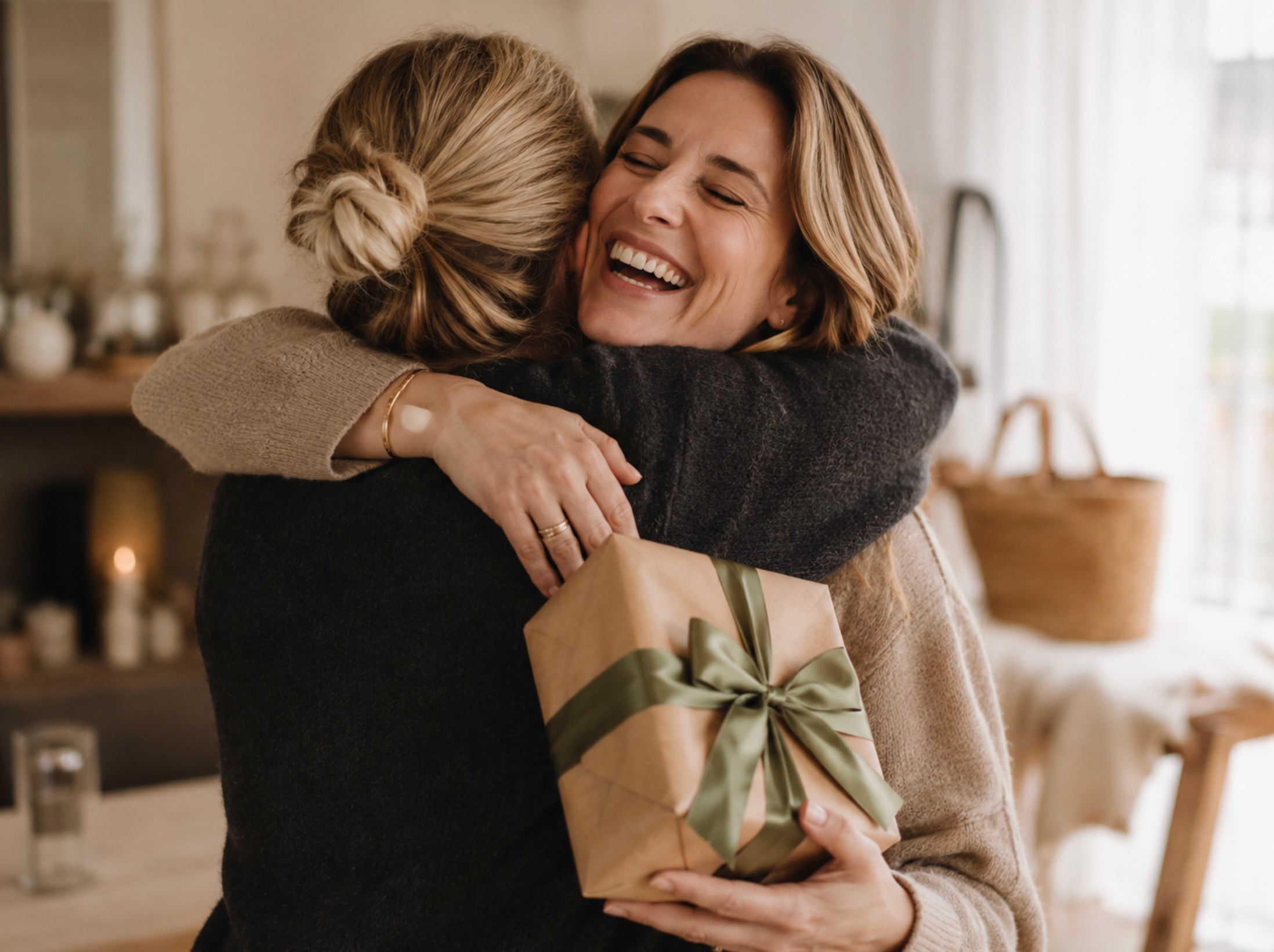 Zwei Frauen umarmen sich herzlich nach der Geschenkübergabe, während sich die Beschenkte sichtbar über das liebevoll verpackte Geschenk freut.
