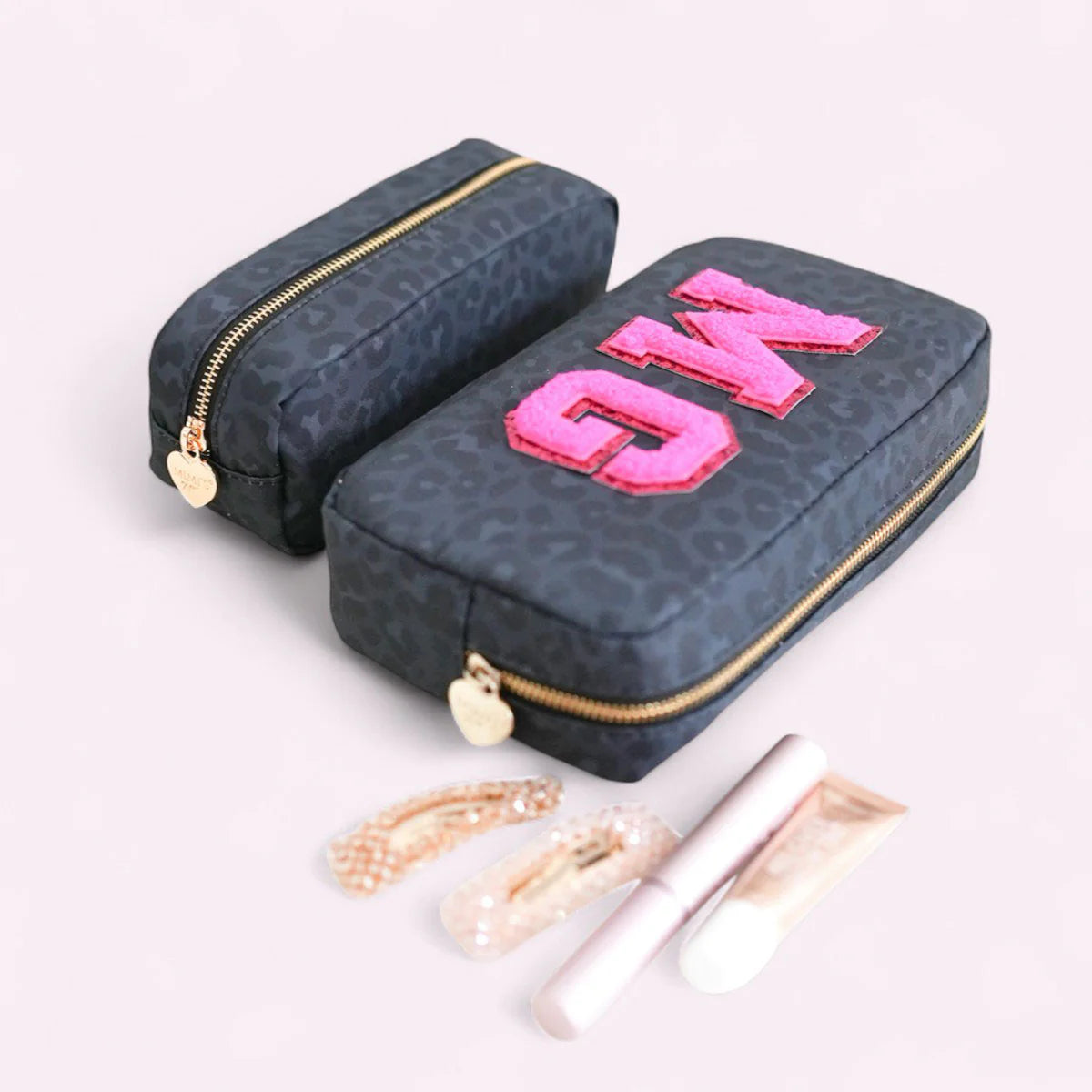 Schwarze Kosmetiktasche mit Leopardenmuster und pinken Glitzer-Buchstaben-Patches von Mimi’s Glow, personalisierbare Beauty Bag mit Initialen und Reißverschluss.