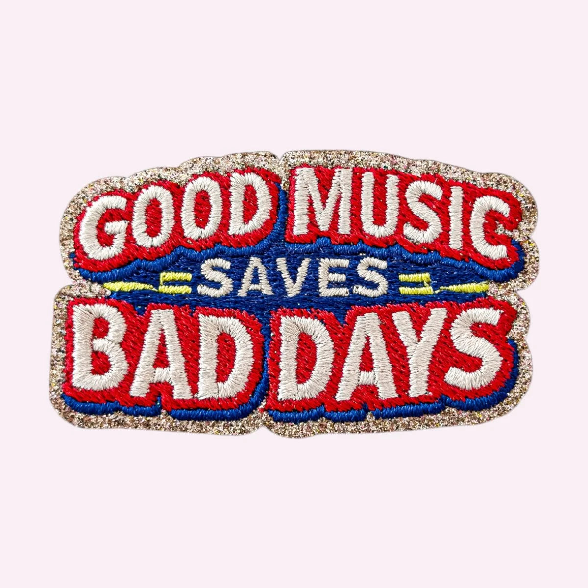 Bestickter Mimi’s Glow Motiv-Sticker „Good Music Saves Bad Days“ in Rot, Blau und Weiß mit goldenem Glitzerrand.